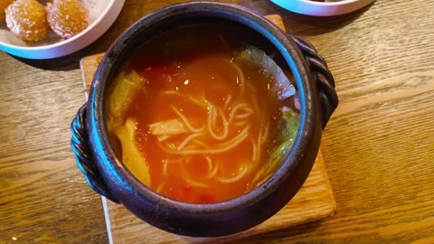 Top down view eating hot steamy boiling tomato rice noodle soup with lettuce, to 動画素材 318258454