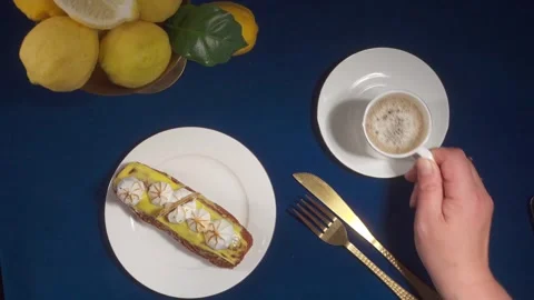 Top-Down View of Eclair and Coffee on Table Stock Footage 335814207
