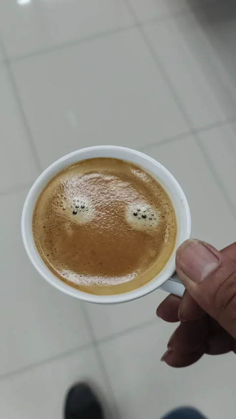 A top-down view of an employee walking and holding a hot espresso cup across the Stock Footage 337359316
