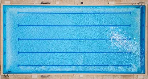 Top-down view of an empty swimming pool with lane dividers and clear blue water Stock Photos