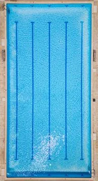 Top-down view of an empty swimming pool with lane dividers and clear blue water Stock Photos