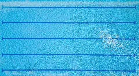 Top-down view of an empty swimming pool with lane dividers and clear blue water Stock Photos