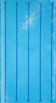 Top-down view of an empty swimming pool with lane dividers and clear blue water Stock Photos