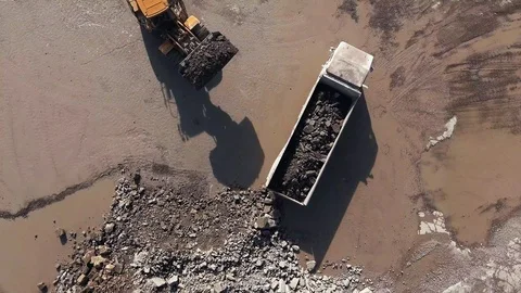 Top down view of an excavator loading rubble and rocks on a truck during Stock Footage 114243577