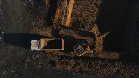 Top down view of an excavator loading sand into a dump truck. drone footage Stock Footage 171468267