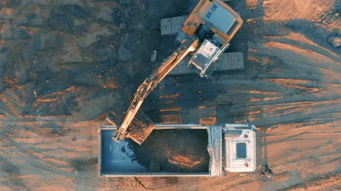 Top down view of an excavator is loading ground into a truck on a building plot Stock Footage 229652727