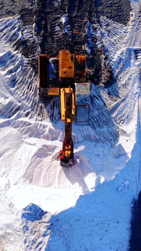 Top down view of excavator loading salt pile, Bulgaria Vertical video. Stock Footage 338008167