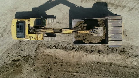 Top Down View An Excavator Loads Rock And Earth Onto A Very Large Dump Truck Video stock 136634364