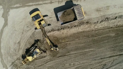 Top Down View An Excavator Loads Rock And Earth Onto A Very Large Dump Truck Video stock 136635159