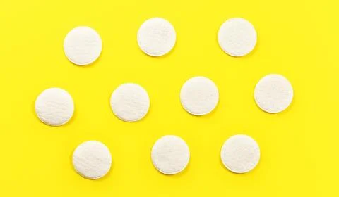 Top down view, face cleaning cotton pads arranged, on yellow board Stock Photos