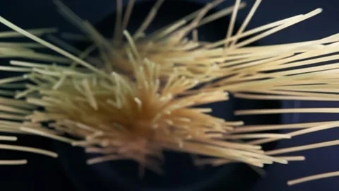 Top down view of falling spaghetti on a black background in slow motion. Stock Footage 280685601