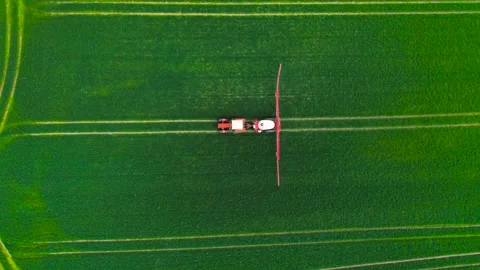 Top down view of farming tractor spraying field for crop treatment. Aerial view Stock Footage 311932594