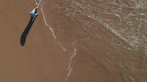 Top down view of father and son playing on a sandy beach with Waves crashing Stock Footage 251875016