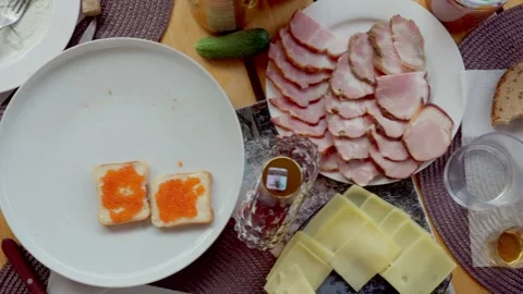 Top down view of feast table with sliced meat cheese and caviar toasts in Stock Footage 343722044