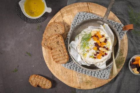 A top-down view features a creamy baked Camembert cheese garnished with dri.. Stock Photos