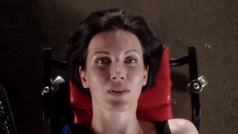 Top down view of female mechanic lying on dolly in car service, looking at Stock Footage 210783385