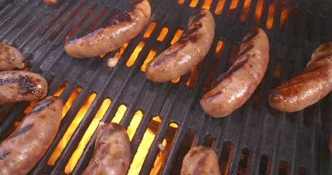 Top down view of a flaming BBQ grill as sausages cook Stock Footage 133651328