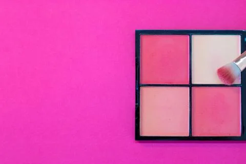 Top down view flat lay of a make up box a with a brush on a pink background.  Stock Photos