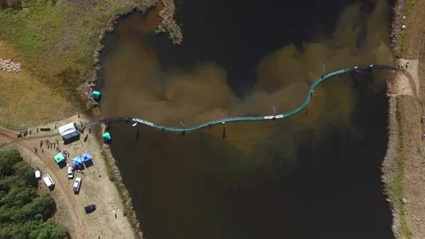 Top down view of floating bridge and mountainbikers crossing Vidéo 131091730