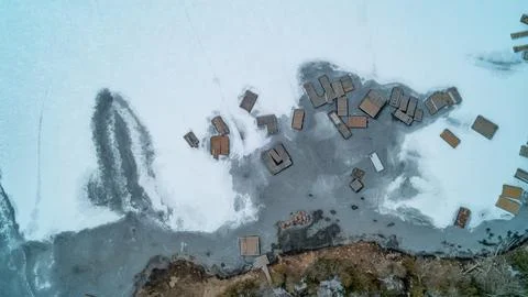 Top Down View of Floating Docks and Ice Patterns on Frozen Lake Shoreline Stock-Fotos