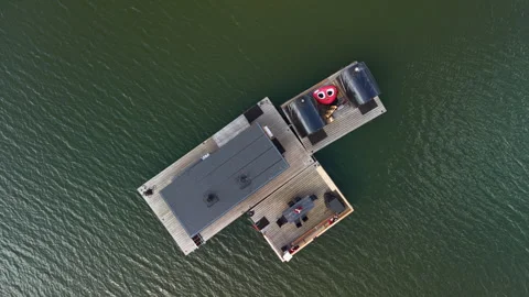 Top-down view of a floating sauna platform on dark green water in Finland Stock Footage 346937414