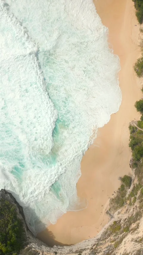 Top-down view of foamy ocean waves crashing onto tropical remote beach Bali Stock Footage 312910929