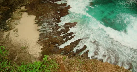 Top down view foamy ocean waves crashing against jagged rocky coastline shore Stock-Footage 327793035