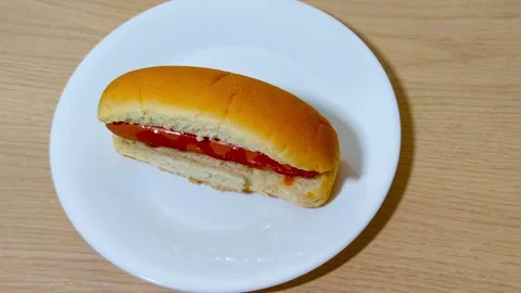 Top down view of fresh hot dog in a bun with sausage served on a white plat.. Stock Footage 318181890