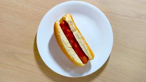 Top down view of fresh hot dog in a bun with sausage served on a white plat.. Stock Footage 318182161