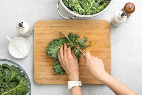 Top down view of fresh kale leaves cut on a cutting board Stock Photos