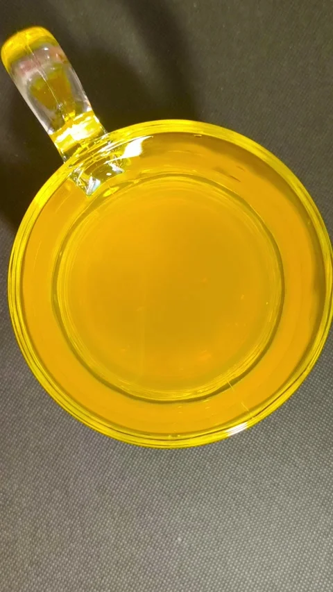 Top-down view of fresh orange juice in a clear handled glass cup on a black.. Stock Footage 318128143