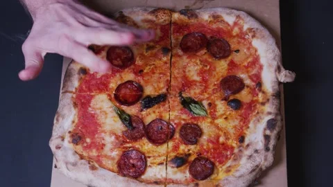 Top-down view of fresh pizza, a man's hand wants to take a bite, but the 動画素材 166218634