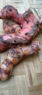 Top Down View of Fresh Red Galangal on Natural Bamboo Mat Stock Photos