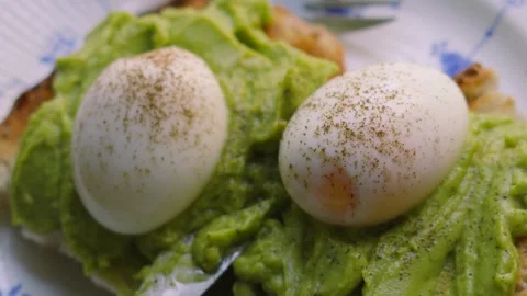 Top Down View of Fresh Soft Boiled Eggs with Fine Pepper with Smashed Avocado Stock Footage 342273803
