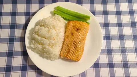 Top down view of freshly cooked delicious salmon with rice and crisp celery  Stockbeeldmateriaal 318254623