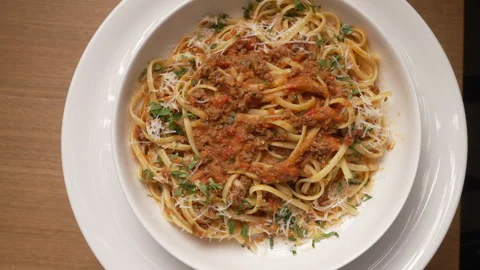 Top-down view of freshly made linguine with bolognese sauce and parmesan cheese Видео 336729429