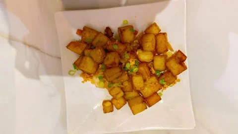Top-down view of fried chili turnip patty on a square plate at a Chinese As.. Stockbeeldmateriaal 318247641