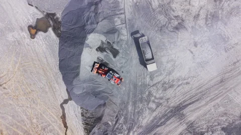 Top down view of front loader filling dump truck with gravel Stock Footage 335691090