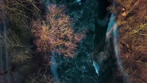 Top Down View Of A Frozen River Surrounded By Trees and A Bridge With People Stock-Footage 132343342