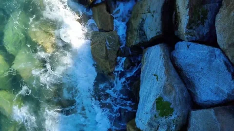 Top Down View of Gentle Waves Breaking on Coastal Rocks Stock Footage 332479386