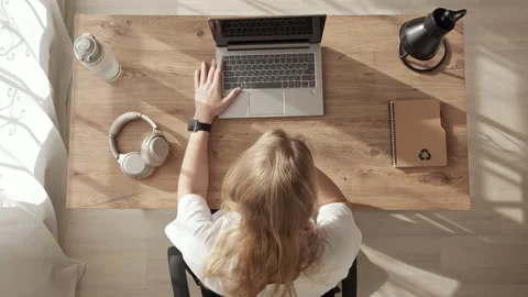 Top-down view girl approaching laptop screen and trying to see something in Video stock 236724995