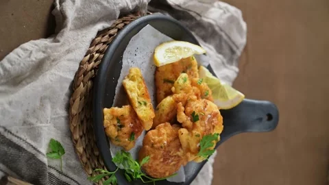 Top-down view of golden cod fish fritters in a black skillet 動画素材 338365545