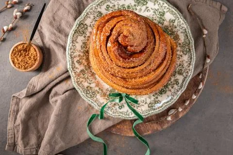 A top-down view of a golden flaky Easter bread roll dusted with sugar on a .. Foto stock