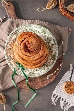 A top-down view of a golden flaky Easter bread roll dusted with sugar on a .. Foto stock