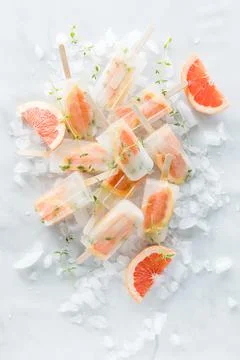 Top down view of grapefruit thyme popsicles on a bed of ice. Stock Photos