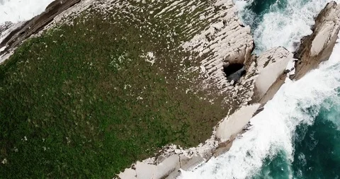 Top down view of green rocky island in ocean. Desert island with a lot of birds Stock Footage 119647032