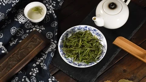 Top Down View of Green Tea Leaves with Teapot in Moody Traditional Setting Stock Footage 340303111
