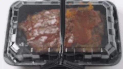 Top down view of grilled meat covered in red barbecue sauce inside a black .. Stock Footage 335359241