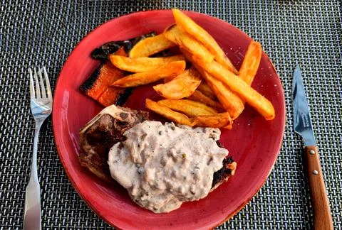 Top-down view of grilled steak with mushroom cream sauce and sweet potato fries Stock Photos