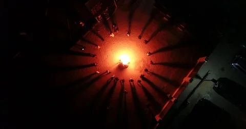 Top down view: A group of people dancing around a camp fire at night Stock Footage 115426337